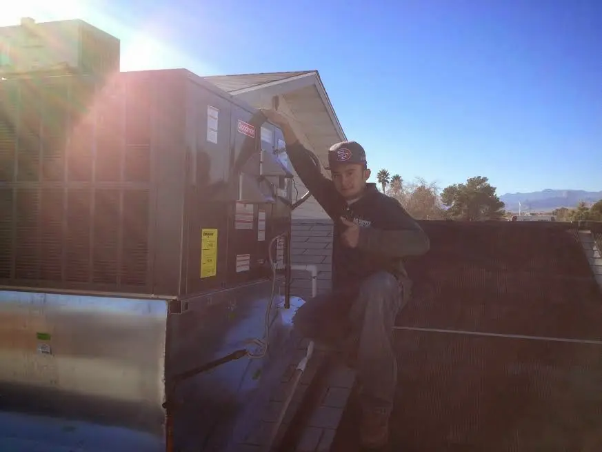 HVAC technician performing Air Duct Cleaning on a rooftop unit in Vernon